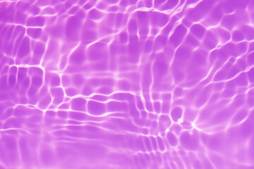 Purple water splashes on the surface ripple blur. Defocus blurred transparent pink colored clear calm water surface texture with splash and bubble. Water waves with shining pattern texture background