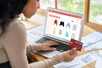Woman shopping online on internet marketplace browsing for sale items for modern lifestyle and use credit card for online payment from wallet protected by crucial cyber security software