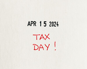 Red 'TAX DAY' alert handwritten with red pen on textured white paper for April 15, 2024, a reminder to file income taxes, flat lay, top-down view