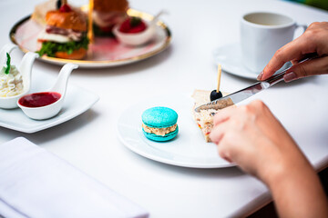 Human hands cutting a sandwich,Sewing and knife in the hands of a girl cut a sandwich in a plate. A woman eats a sandwich in a light restaurant. Cutlery in the hands of a close-up. Cut the sandwich wi