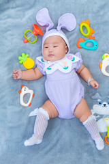 Baby boy in bunny costume,Cute baby Easter bunny. Little baby boy with bunny ears and Easter eggs in wicker basket in white fur. Symbol of Easter holiday, birth, spring, religion