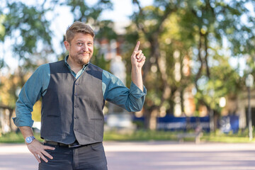 Young businessman presenting, pointing, outdoors