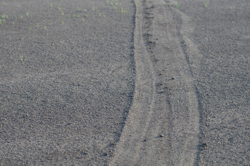 sandy ground with tire tracks