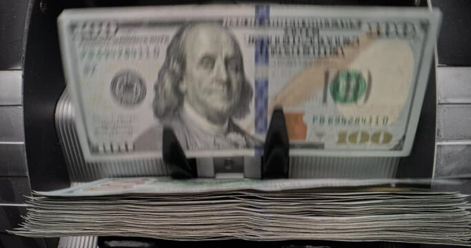 Counting hundred dollar bills in counting machine. Financial transaction management slow motion, smooth motion. Counting cash for financial transactions. Brand new banknotes rustle like leaves in wind