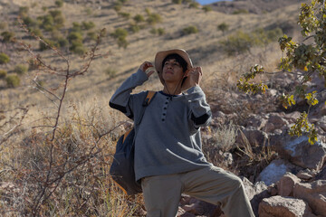 Naklejka premium Young man with backpack wears hat on his vacation to protect himself from the sun for hiking in a mountain in Mexico