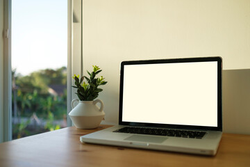 Fototapeta premium Mockup laptop computer with empty display on wood table.