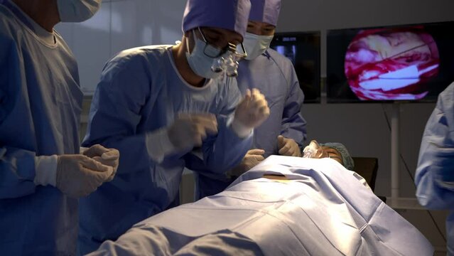 Professional surgical team to operate female patient under anesthesia on bed