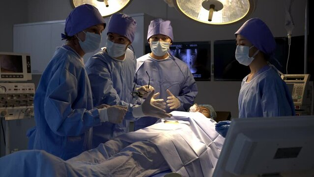 Professional surgical team to operate female patient under anesthesia on bed