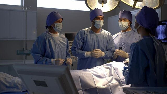 Professional surgical team to operate female patient under anesthesia on bed