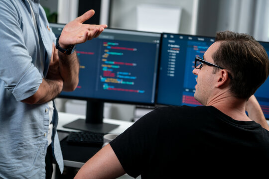 IT developers discussing online software development information on pc screen, creating program coding for latest version application on website. Concept of brainstorming firmware updated. Sellable.