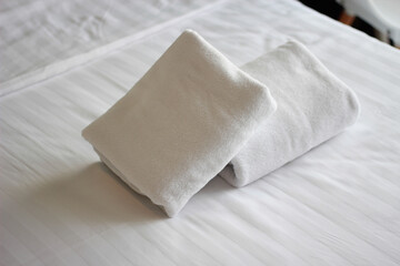 Clean towels on bed at hotel room and copy space.