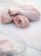 raw chicken thighs in white cutting board 