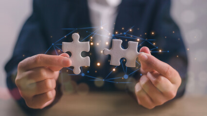 Business solutions, success, and strategy concept. Businessman hand connecting jigsaw puzzle.