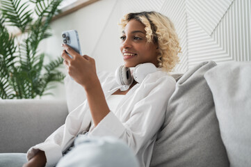 Side view on relaxed woman sitting on the couch watching videos on streaming service,social...