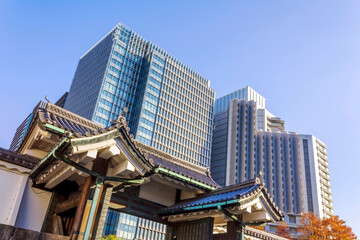 The Otemon Gates to the Imperial Palace East Gardens with modern skyscrapers of Marunouchi commercial district in the background in Tokyo, Japan. 