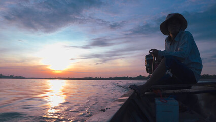 Silhouette of a fishermen on boat with outboard motor boat ready to fishing during beautiful...