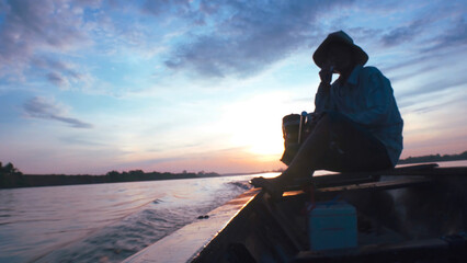 Silhouette of a fishermen on boat with outboard motor boat ready to fishing during beautiful...