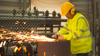 Professional heavy industry workers wearing safety suits using angle grinders and metal pipe cutters.
