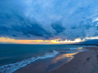 Colorful sunset on the sea. Mountain lake in the rays of the orange sun. Kyrgyzstan, Lake Issyk-Kul. natural background