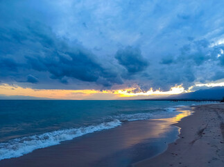 Colorful sunset on the sea. Mountain lake in the rays of the orange sun. Kyrgyzstan, Lake...