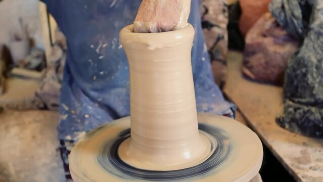 Man at pottery workshop. Unrecognized man producing pitcher from clay at pottery shop in Bahrain