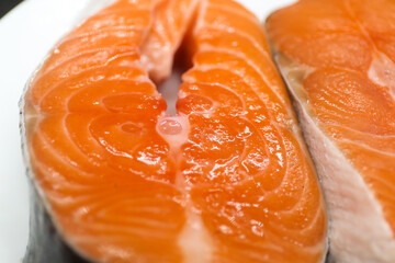 Two juicy salmon steaks on a white plate