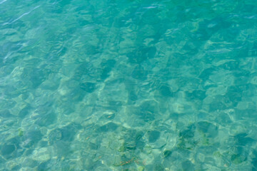 Fototapeta na wymiar Clean transparent sea water, lake bottom and sand. Beautiful blue, turquoise transparent surface