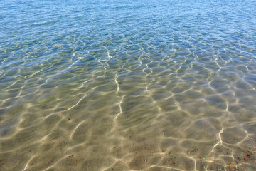 Clean transparent sea water, lake bottom and sand. Beautiful blue, turquoise transparent surface