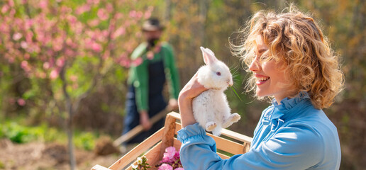 Couple of young farmers in farm, spring banner. Pretty girl preparing for Easter. Spring. Woman and...