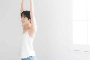 Woman stretching and stretching and taking deep breaths by the window