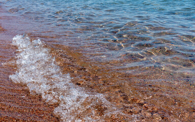 Fototapeta na wymiar Clean transparent water, wave on the sand. Coastline. Kyrgyzstan, Lake Issyk-Kul. natural background.