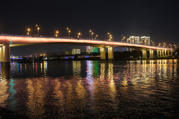Fototapeta na wymiar Nanning city,Guangxi province, China at night. Bridge over Yong River with reflection