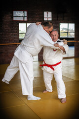 Judo sensei master instructor in traditional gi kimono demonstrate judo throw technique on tatami