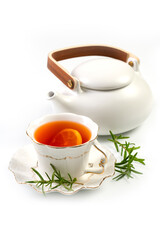 White porcelain cup with a tea and a tea pot