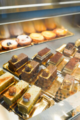 Gourmet cakes and pastries in a bakery display case.