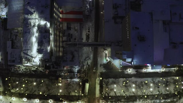 High drone of cars and vehicles driving on the snowy urban roads ofa city at night