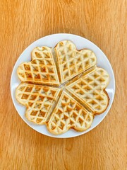 Honeycomb candy is delicious (Thailand) on a wooden background.Heart shape sweet waffles isolated on wooden floor background.
