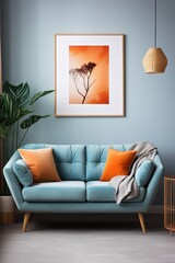 Blue sofa with orange pillows and a picture of a tree on the wall