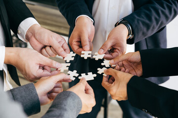 Business people with jigsaw puzzle pieces in office, Successful teamwork and partnership concept.