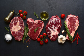 Different types of raw marbled beef steaks : T-bone, ossobuko, spider and rib eye with ingredients...