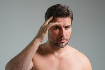 Obraz premium Mens skincare. Attractive man with perfect skin touch face after shaving. Skin care healthcare cosmetic procedures concept. Close up man with sensitive skin, male cosmetology treatment. Skin care.