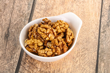 Cracked unshelled walnut in the bowl