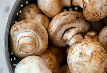 Raw mushrooms in an iron bowl on a white wooden background