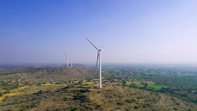 Aerial drone shot flying away from windmill wind turbine generators in Jaisalmer Rajasthan Gujarat showing alternate renewable energy sources in thar desert and aravalli range