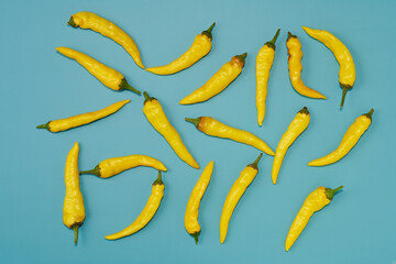 黄色系唐辛子をランダムに複数配置した緑色系背景あり真俯瞰撮影