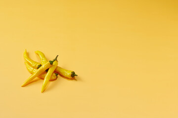 黄色系唐辛子を複数左下に複数配置した黄色系背景あり俯瞰撮影