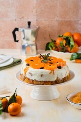 Jelly cake with a creamy part, spiced cupcake and tangerine on a white cake stand on a light concrete background. Dessert recipes