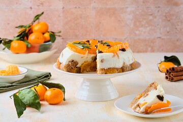 Jelly cake with a creamy part, spiced cupcake and tangerine on a white cake stand on a light concrete background. Dessert recipes