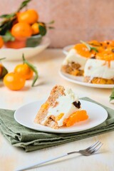Jelly cake with a creamy part, spiced cupcake and tangerine on a white cake stand on a light concrete background. Dessert recipes