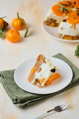 Jelly cake with a creamy part, spiced cupcake and tangerine on a white cake stand on a light concrete background. Dessert recipes